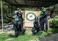 Four Mosquito Lightning security team members pose for a photo in front of the Mosquito Lightning logo with guns aimed at the camera.