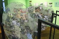 Illustrations and pieces of text, many of which look aged and damaged, are displayed between clear glass circles.