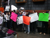Color photograph of protestors holding signs.