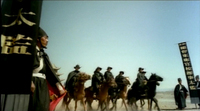 Soldiers on horses carry tall black banners with writing on them.