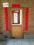 An image of a banner with black calligraphy, posted to a door.