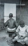 Bunu Yoruba woman weaving on vertical single-heddle loom.