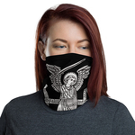 This photograph shows a woman wearing a black facial mask/covering with a white image of Saint Michael, an angel with a sword ready to fight evil.