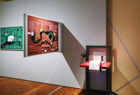 Two jars of coffee beans set on a stand beside a hanging infographic about coffee.